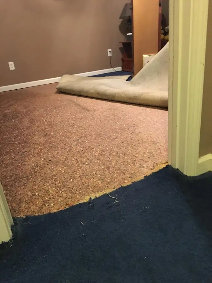 Carpet pad removal revealing water damage during Water Mitigation Services in Yankton